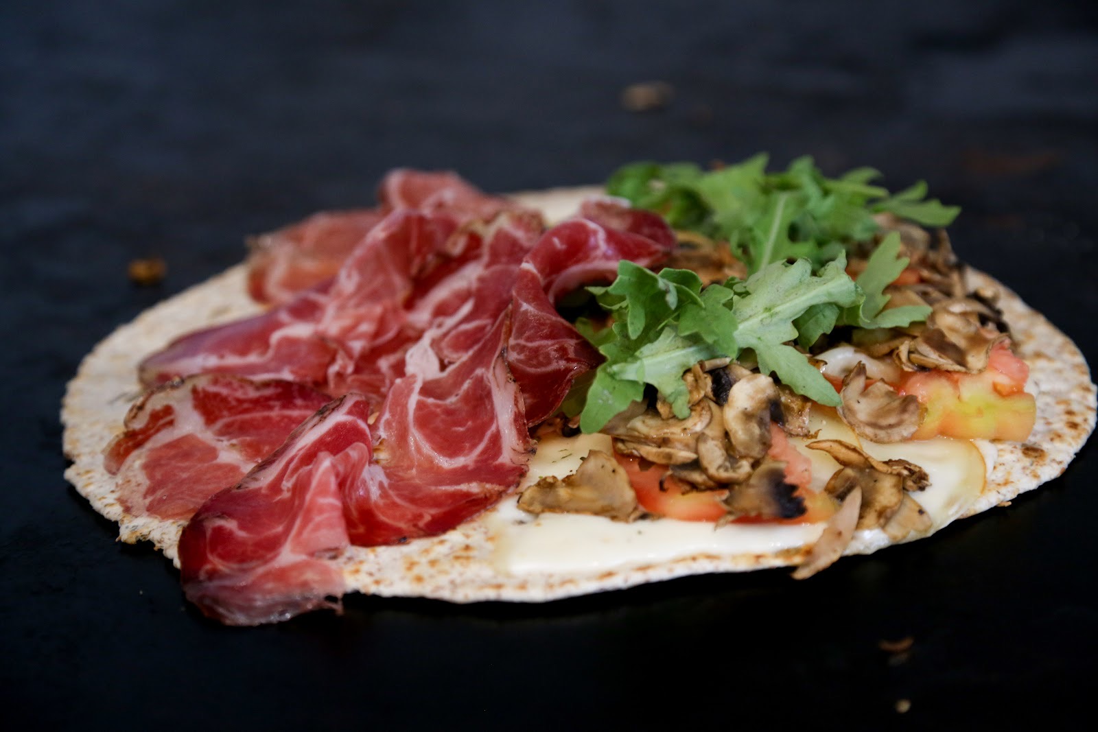 Piadina farcita con crudo, funghi, rucola e formaggio